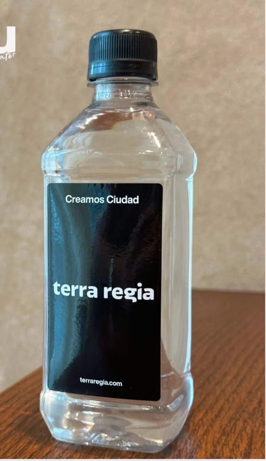 Botella cuadrada de 500 ml con etiqueta vertical negra de una desarrolladora inmobiliaria